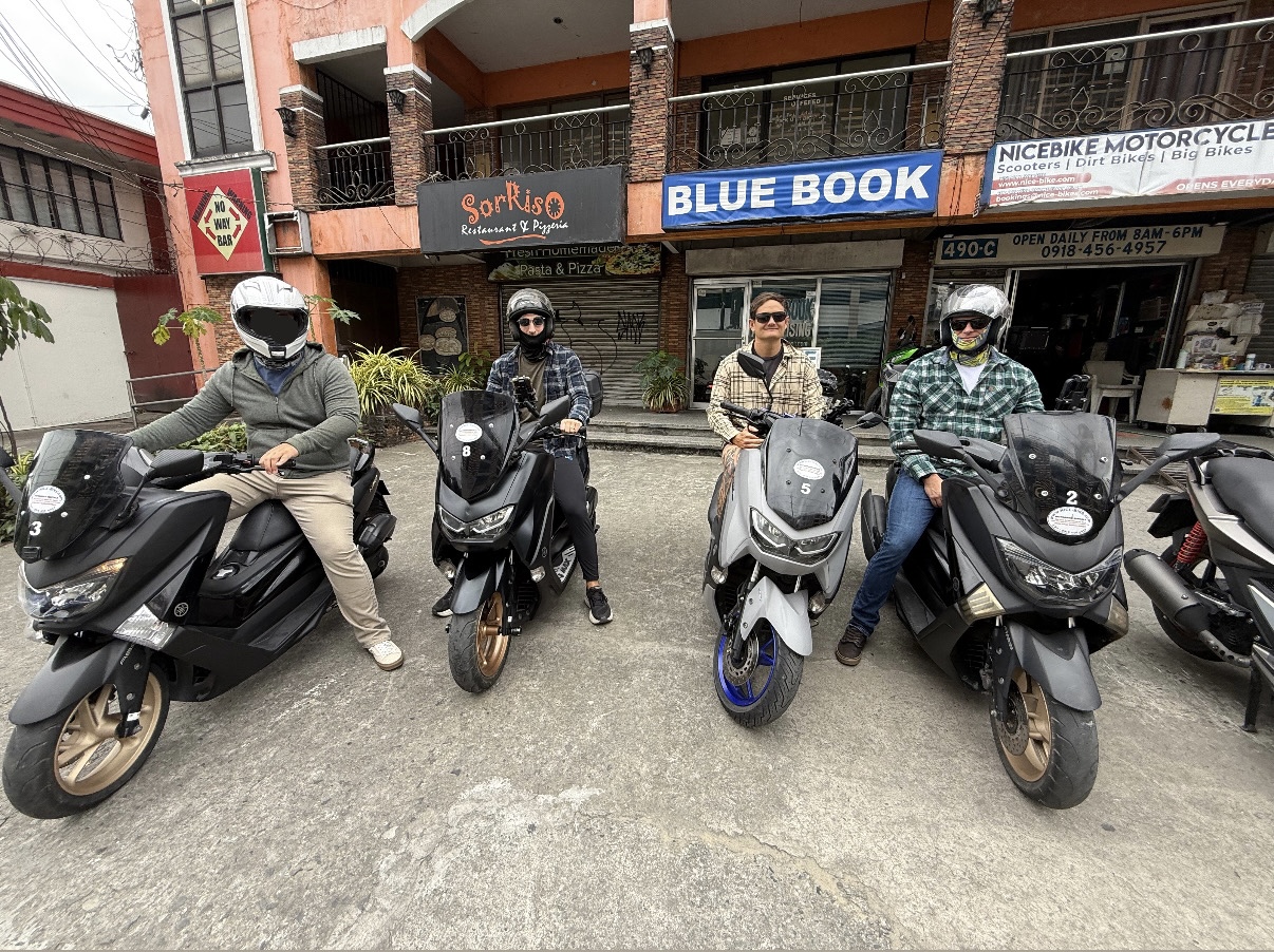 Four customers with scooters outside NiceBike Motorcycle Rentals